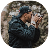 a man taking a photo in the woods